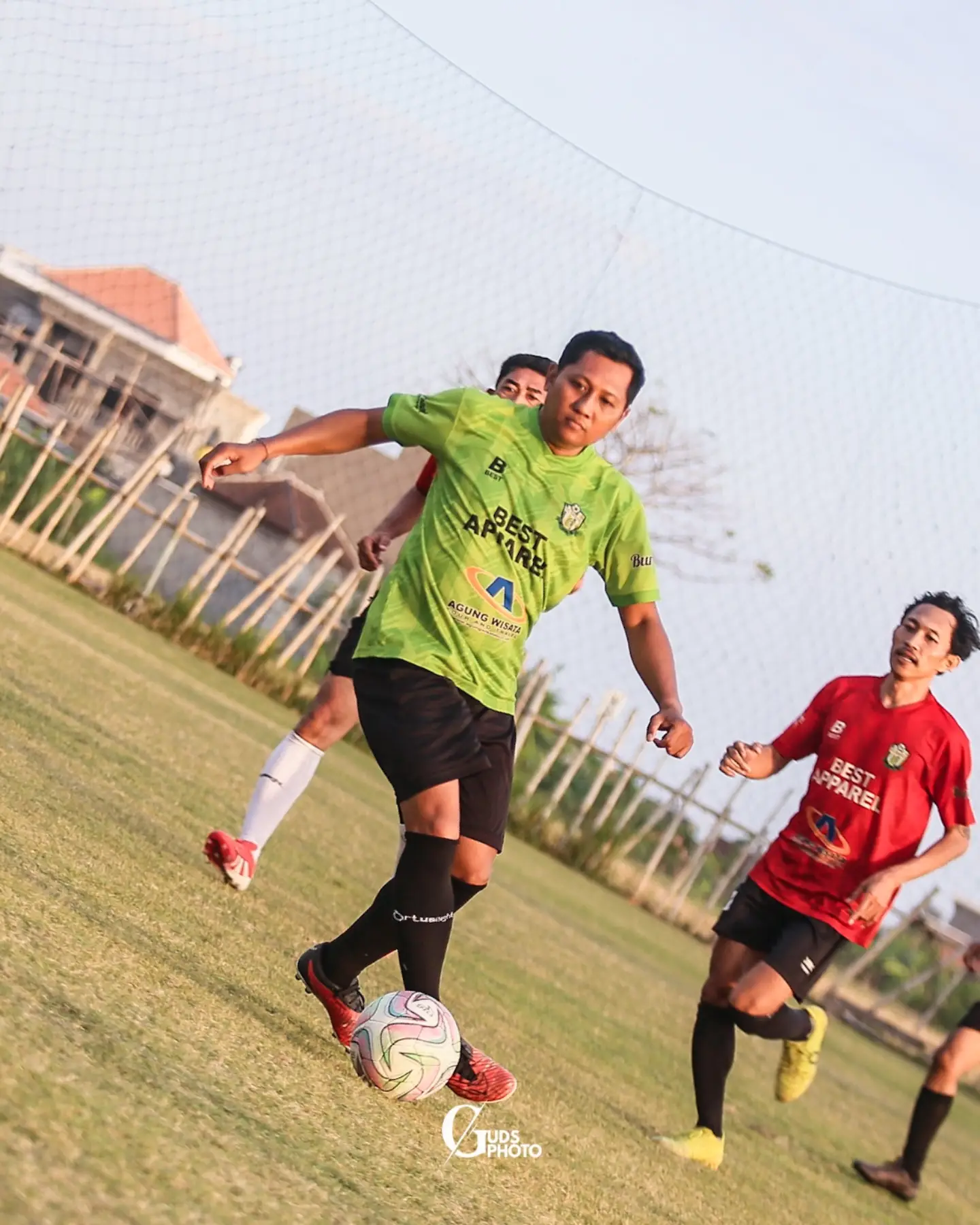 Pemain berjersey hijau mengontrol bola